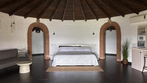 a bedroom with a bed and a couch in a room at complejo rural el prado in Logrosán