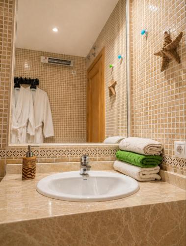 a bathroom with a sink and a mirror and towels at El Respiro in Ruidera