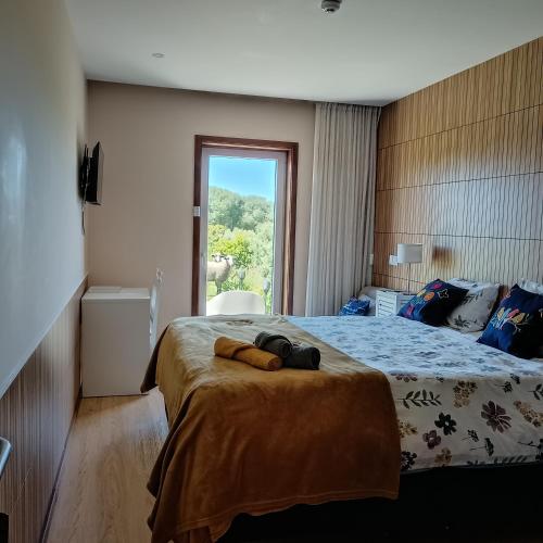 a bedroom with a large bed with a window at Moimenta Guest House in Mindelo