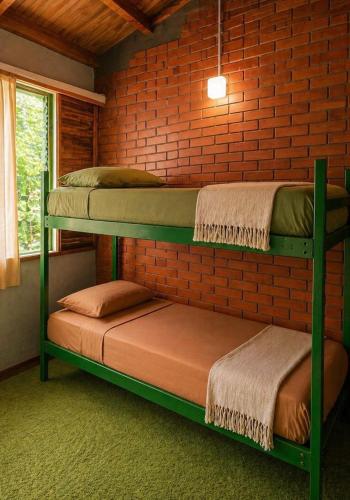 two bunk beds in a room with a brick wall at OlasHostel in Mendoza