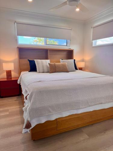 a bedroom with a large bed with two windows at Spacious Private 2BR Guest Suite in Gold Coast
