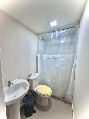 a bathroom with a white toilet and a sink at Casa de campo em meio a natureza in Araras Petropolis