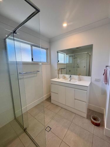 a bathroom with a sink and a glass shower at Spacious Private 2BR Guest Suite in Gold Coast