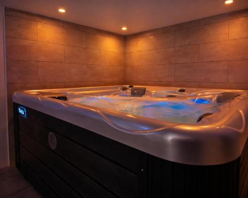 a large bath tub in a room with at Le Bain des VioIettes - Grand jacuzzi privatif in Dole