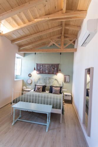 a room with a bed and a wooden ceiling at Almond Suite in Hydra
