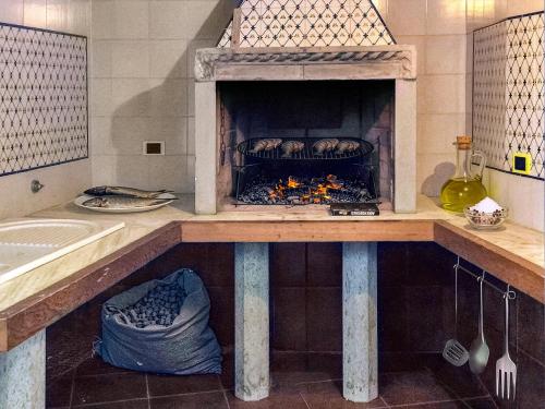 a kitchen with a fireplace with bread in it at Villa Velta Calagrande in Porto Santo Stefano