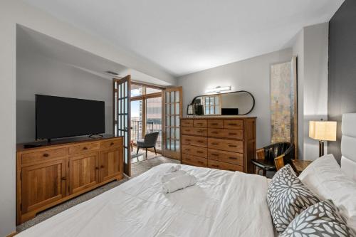 a bedroom with a bed and a flat screen tv at 1777 Larimer 2211 in Denver
