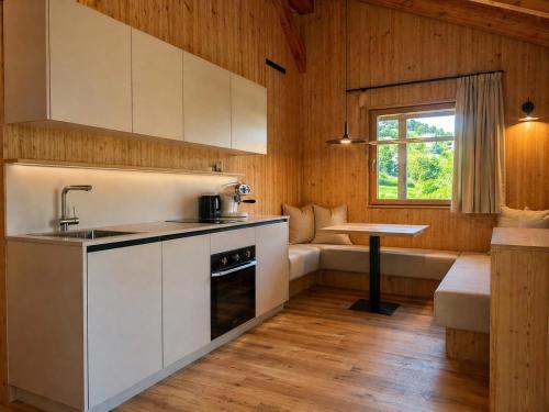 a kitchen with white cabinets and a table and a window at Garnì Lilly in San Lorenzo in Banale