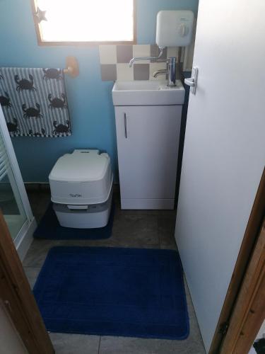 ein kleines Badezimmer mit Waschbecken und Toilette in der Unterkunft Oceans End in Bacton