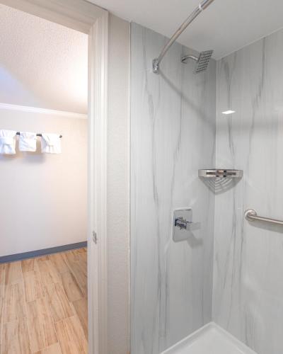 a shower with a glass door in a bathroom at Gateway Inn in Graham