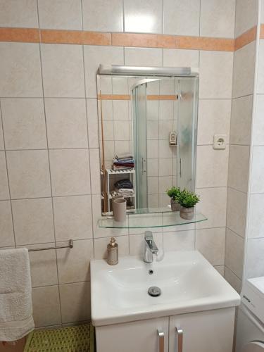 a bathroom with a white sink and a mirror at Guest house Gloria in Šilo