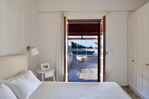 a bedroom with a bed and a door to a patio at Vista Petros in Apraos