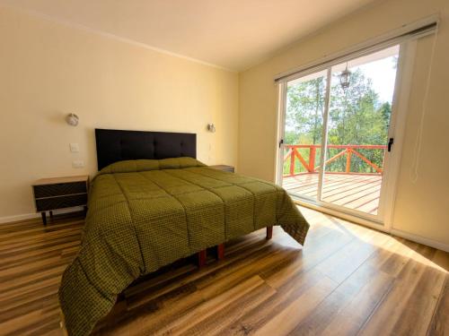 a bedroom with a bed and a large window at Arriendo casa Caburgua Pucón in Caburgua