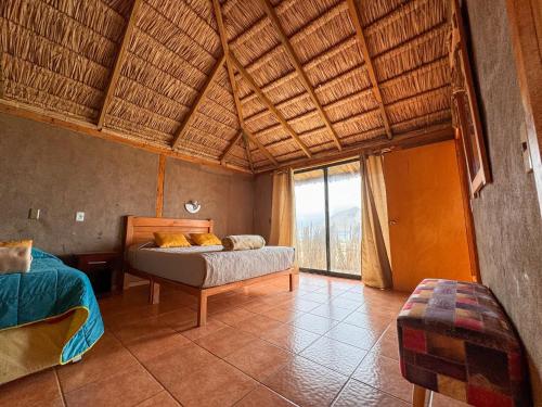 a bedroom with a bed and a large window at Pan de Azúcar Lodge in Ciudad de Chañaral