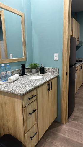a bathroom with a sink and a mirror at Churros Apartahotel in La Libertad