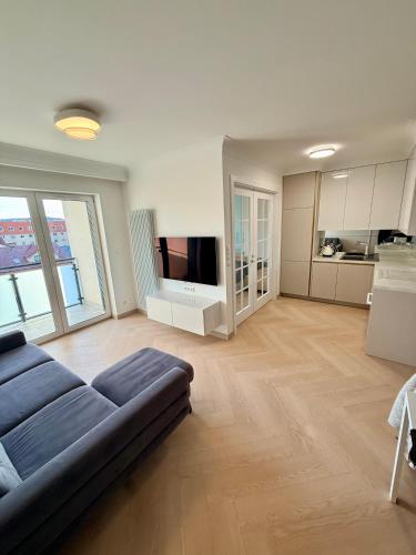 a large living room with a couch and a television at Olimpia Luxury Apartment in Lębork