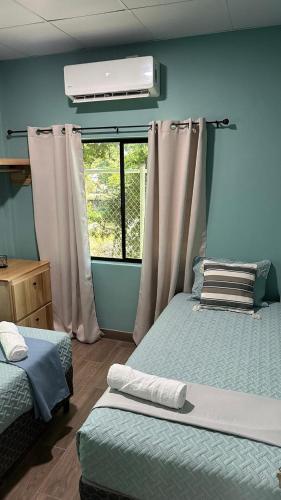 a bedroom with two beds and a window at Churros Apartahotel in La Libertad