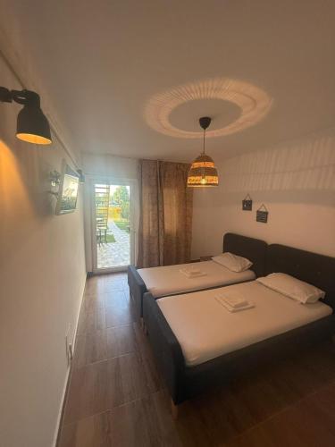 a hotel room with two beds and a window at Casa Maria in Vama Veche
