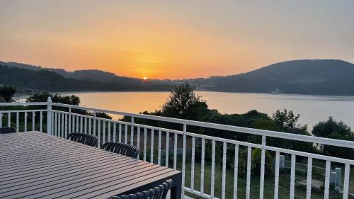 a balcony with a view of a lake at sunset at The Cliffs - ArealongaBeach in O Vicedo