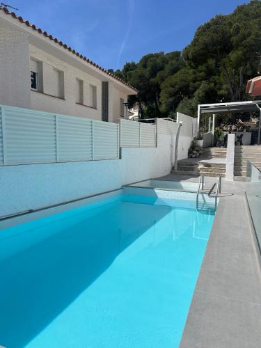 a blue swimming pool in front of a building at Casa Roca Maura in L'Estartit