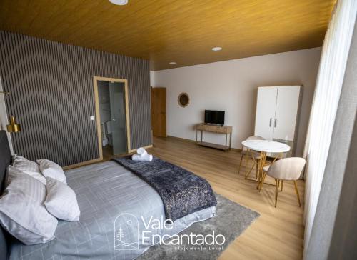 a bedroom with a bed and a table and a desk at Vale Encantado in Parada de Ester