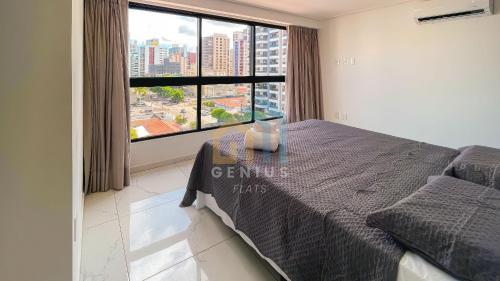 a bedroom with a bed and a large window at Move Tambaú Genius Flats in João Pessoa