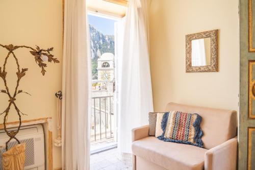 a living room with a chair and a window at Palazzo Nobili in Capri