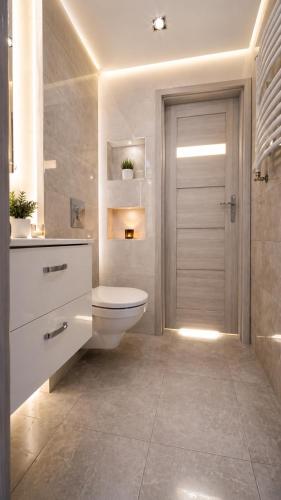 a bathroom with a toilet and a shower and a door at Szafir Kuźnica - Apartamenty 4 min od plaży in Kuźnica
