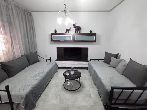 a living room with two couches and a tv at Rosemary Guesthouse in Kavála