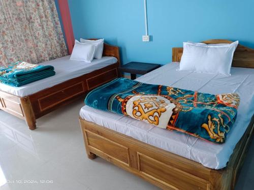 two beds sitting next to each other in a room at Chamling Retreat in Kalimpong