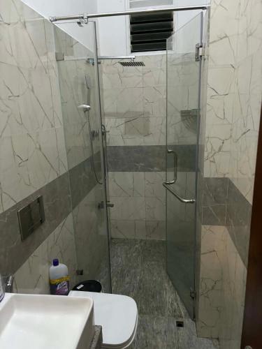 a bathroom with a glass shower with a toilet and a sink at Colombo - Kelaniya House in Kelaniya