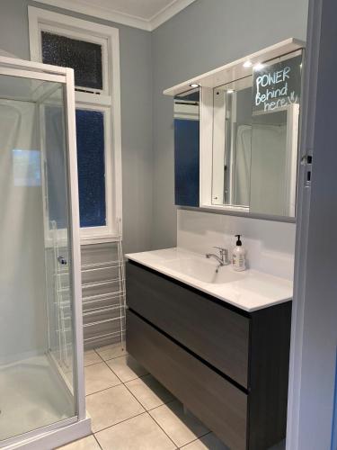 a bathroom with a sink and a shower and a mirror at Marvellous on Maggie in Invercargill