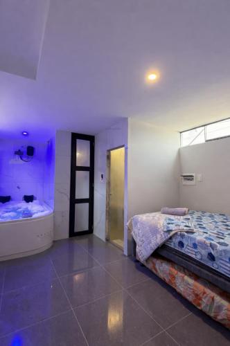 a bedroom with a bed and a tub in it at Peruyork - Sauna & Jacuzzi in Chiclayo