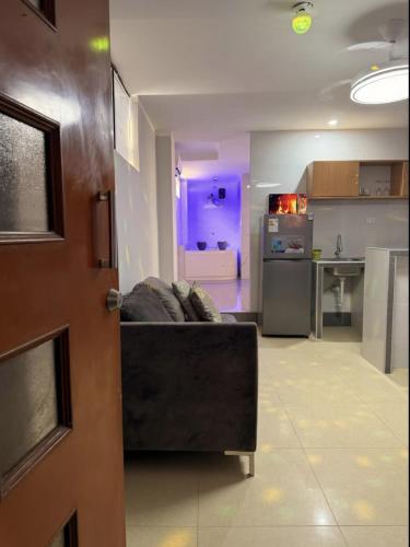 a living room with a couch and a kitchen at Peruyork - Sauna & Jacuzzi in Chiclayo