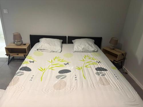 a bed with a bedspread with plants on it at Maison perthois in Saint-Dizier