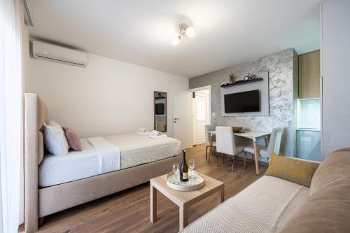 a bedroom with a bed and a living room at Hillside Apartments in Bečići