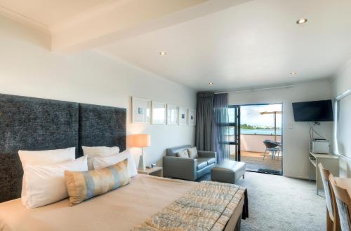 a bedroom with a large bed and a living room at Marineland Beachfront Accommodation in Napier