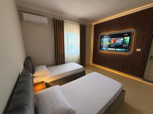 a hotel room with a couch and a tv at Apartments Vila Ardi in Sarandë