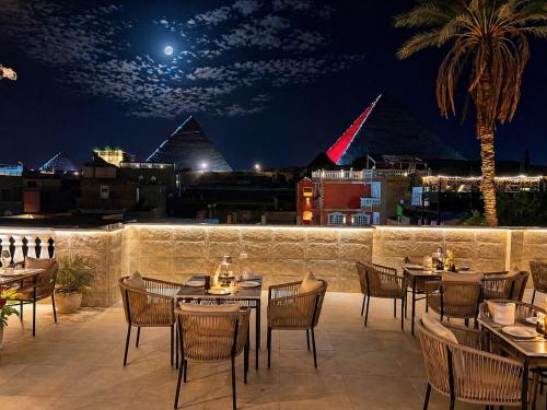 a restaurant with tables and chairs on a patio at night at Calm Pyramids View Villa in Cairo