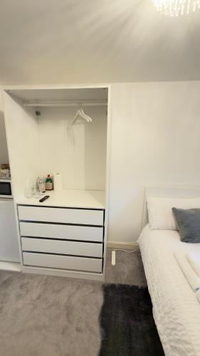 a white bedroom with a bed and a white dresser at Suite 2 En-suite Room with Double Bed in Edinburgh