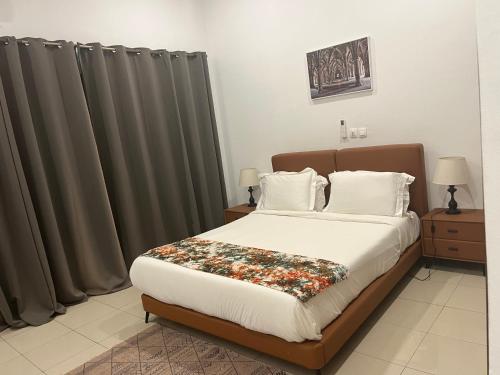 a bedroom with a large bed with gray curtains at Villa Abou in Assinie