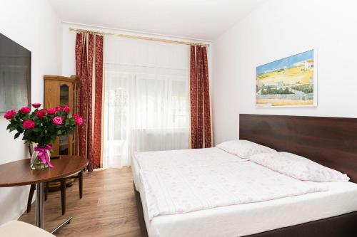 a bedroom with a bed and a table with a vase of flowers at Villa Swarzewo in Swarzewo