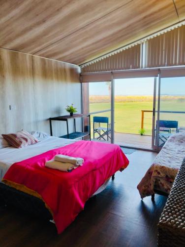 a bedroom with a large bed with a red blanket at Melincue Arenas in Melincué