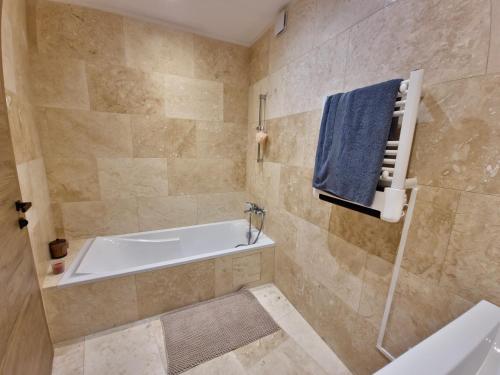 a bathroom with a tub and a blue towel at Apt Belvedere in Apt