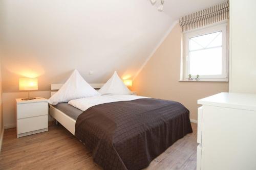 a bedroom with a large bed with a window at Kleine-Auszeit in Greetsiel