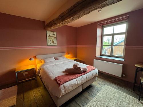 a bedroom with a bed with two stuffed animals on it at L' Ecole in Durbuy
