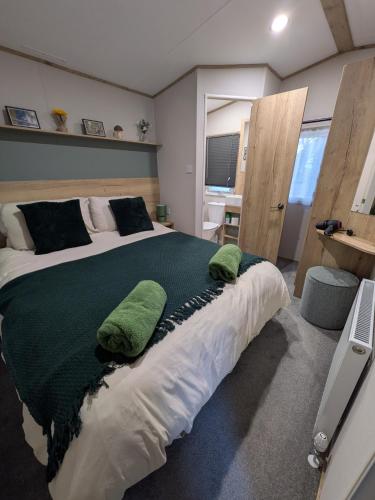 a bedroom with a large bed with green pillows on it at Boat 32 in Boat of Garten