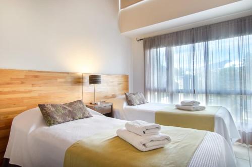 a hotel room with two beds and a window at Balcones al Nahuel II in San Carlos de Bariloche