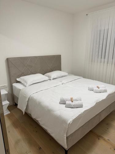 a large white bed with two white towels on it at Apartman Royal in Posušje