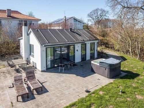 a house with a hot tub and chairs on a patio at Retreat with Outdoor Whirlpool in Årøsund
